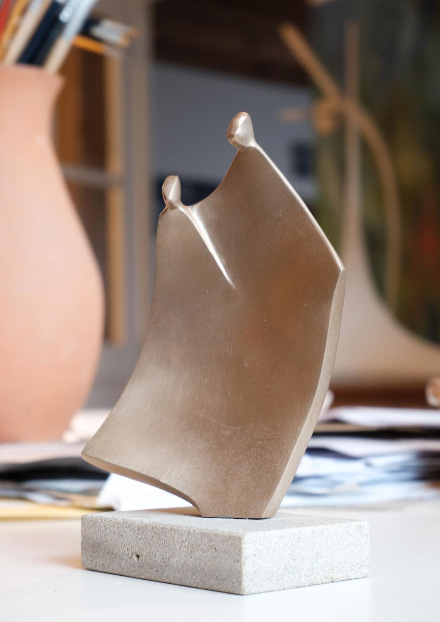 Sculpture Affection de l'Atelier Philippe Gancel en bronze  poli avec deux formes de têtes stylisées sur une base rectangulaire en pierre.
