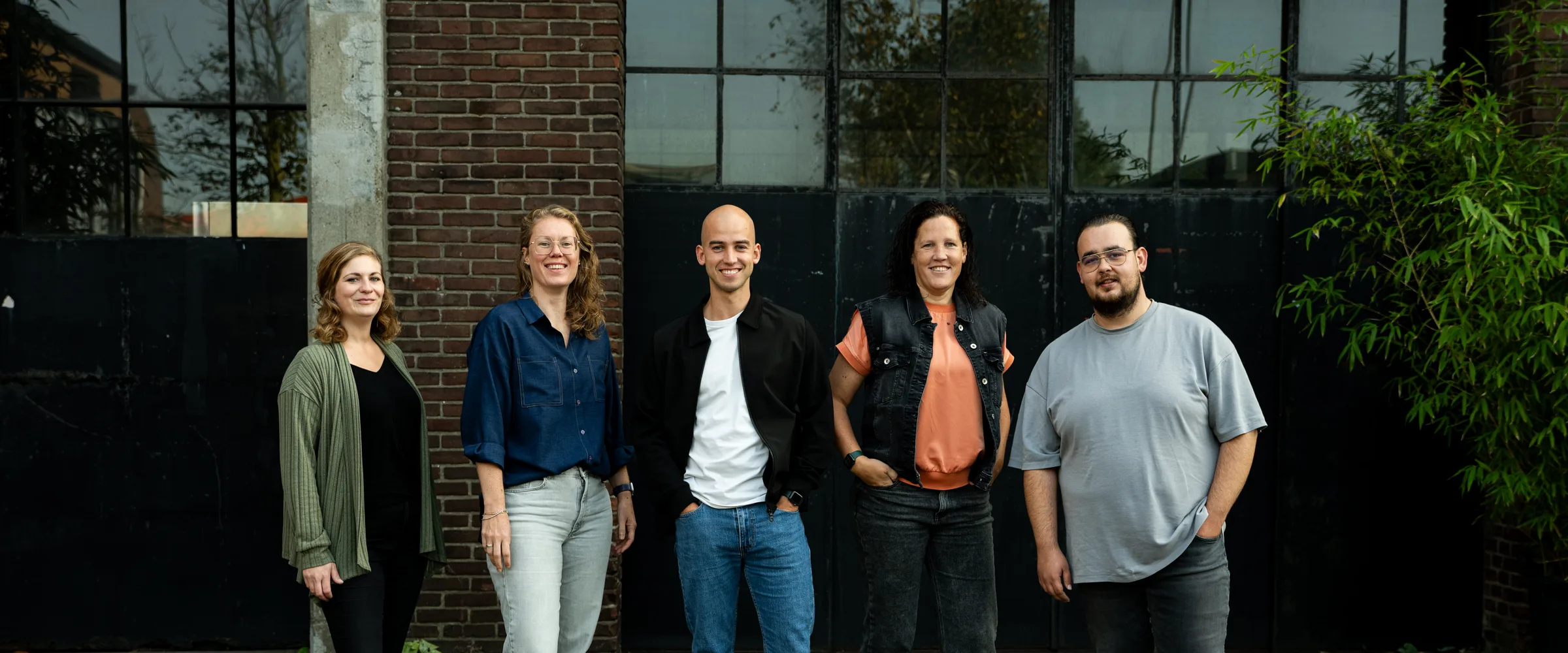 Het team van Buro Staal staat naast elkaar voor de fabriekshal.