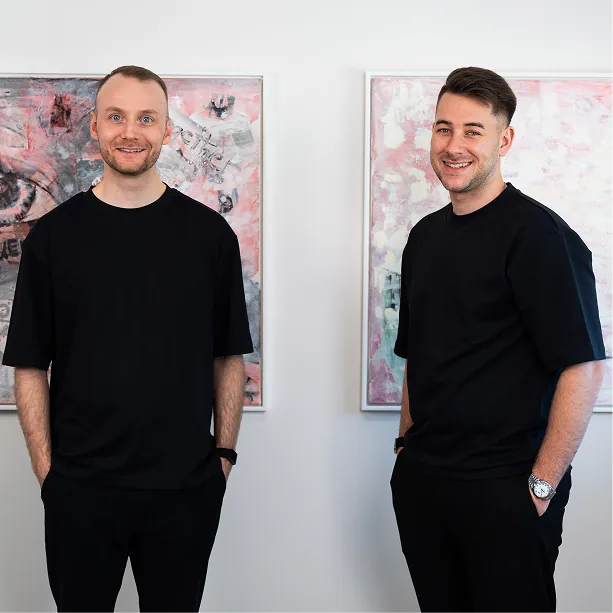Zwei Teammitglieder vor Kunstwerken