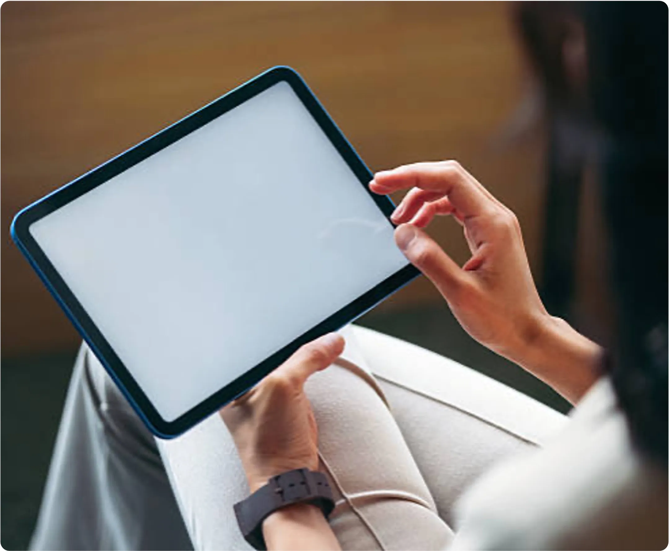 Person hält ein Tablet mit leerem Bildschirm und berührt den Bildschirm mit dem Finger.