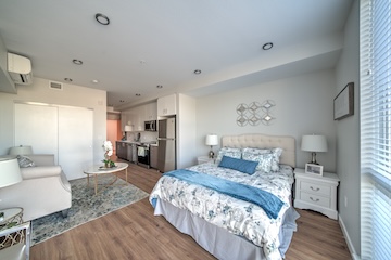 Studio full with kitchen with white and brown cabinets