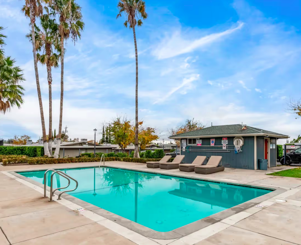 Swimming pool with lounge chairs around it.