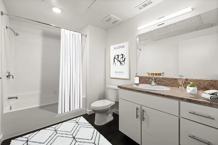 Bathroom with vanity, white cabinets, and shower tub combo