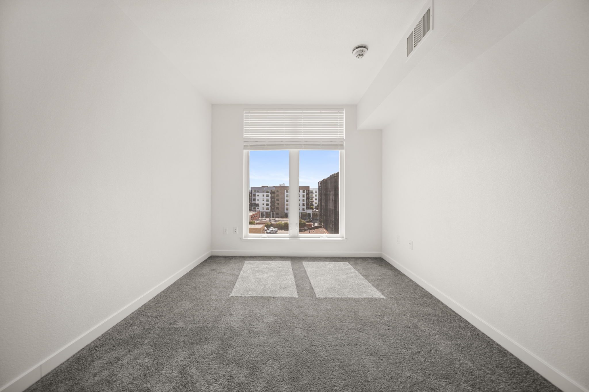 Unfurnished bedroom with carpet and large window