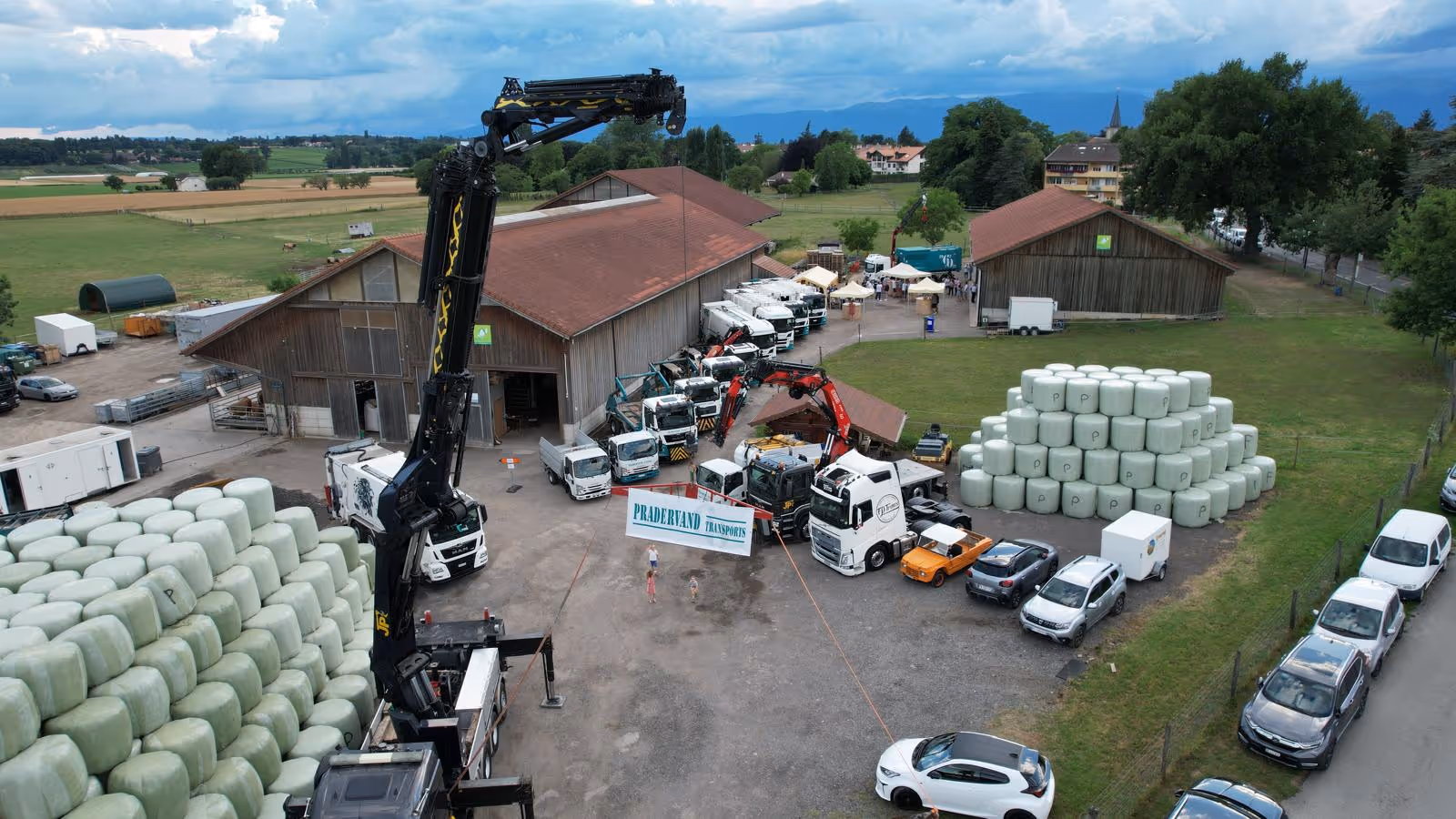 Une équipe de onze hommes debout devant un hélicoptère gris et rouge marqué SAF International, posant sur une surface rouge avec un paysage montagneux en arrière-plan.