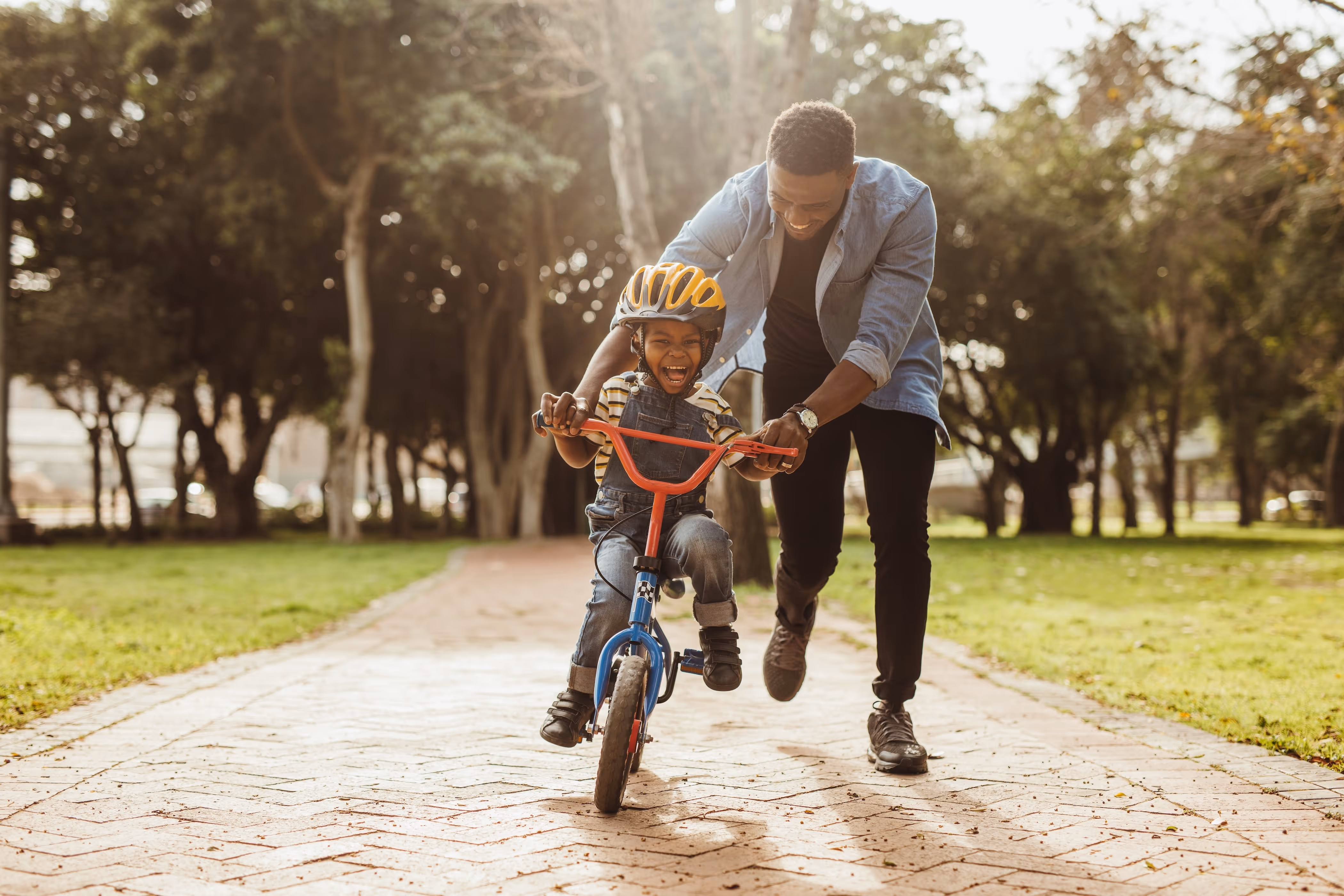 Kid riding a bike with parent helping stock image