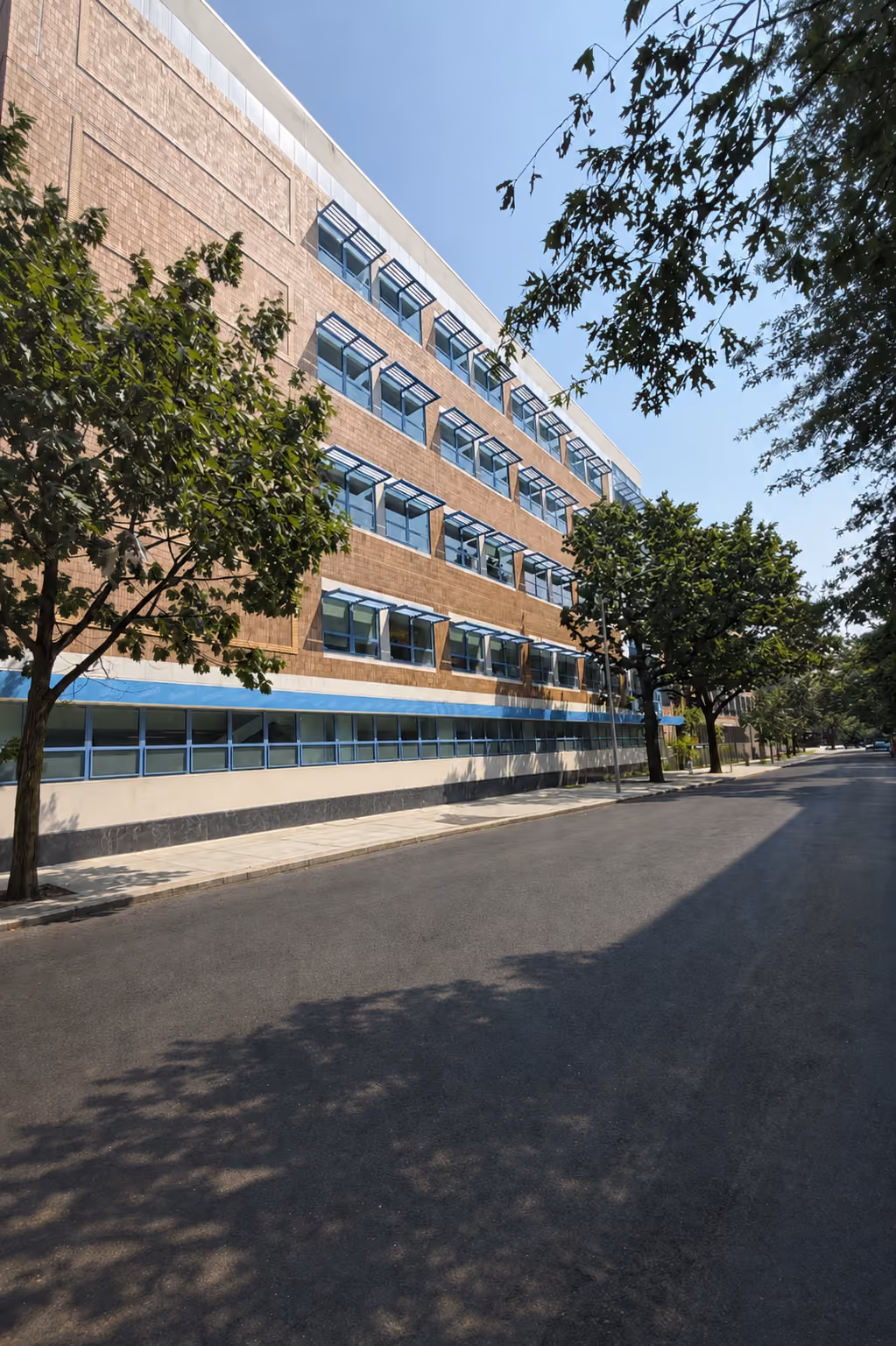 Exterior view of PS 105 school building with tree-lined street