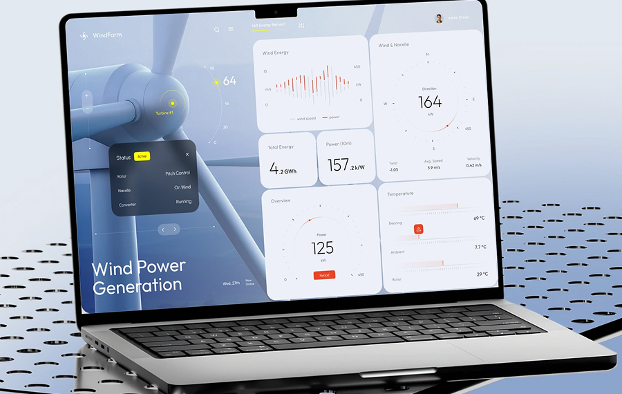 Laptop screen displaying a wind power generation dashboard with turbine status, wind energy graphs, total energy, power metrics, wind direction, and temperature readings.
