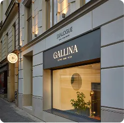 Obchodní výloha kavárny Gallina se skleněnou stěnou a rostlinami uvnitř.