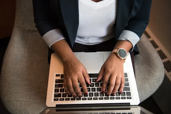 Birds eye view of women in a char typing on a keyboard. 
