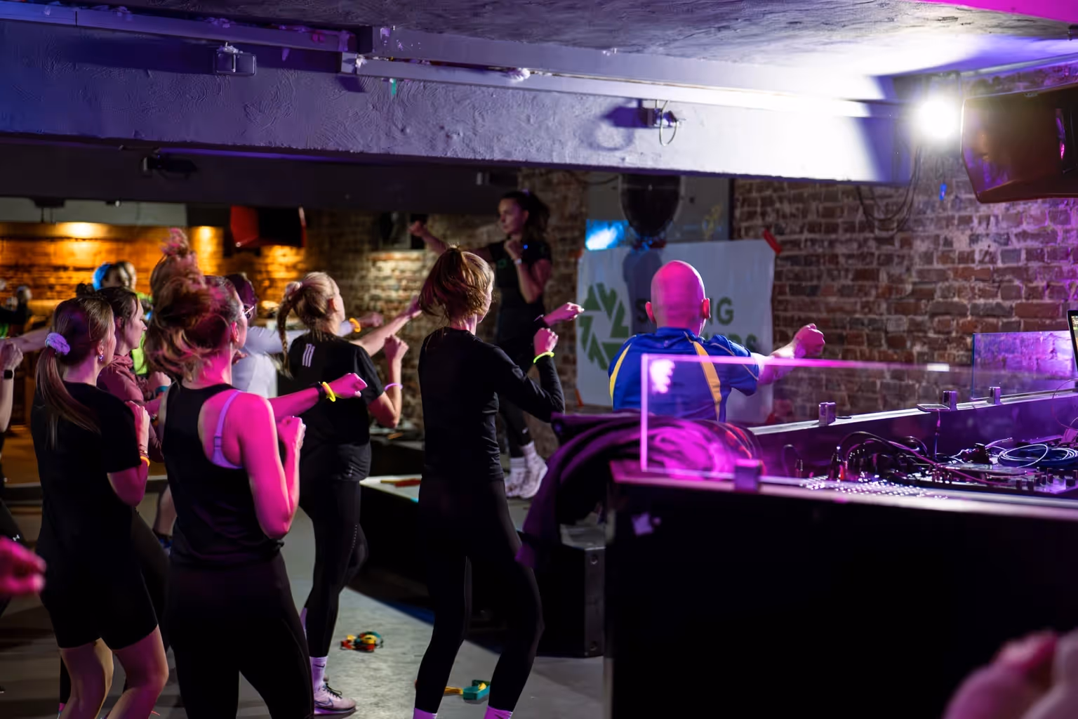 Kursteilnehmer bewegen sich in dunkler Club-Atmosphäre