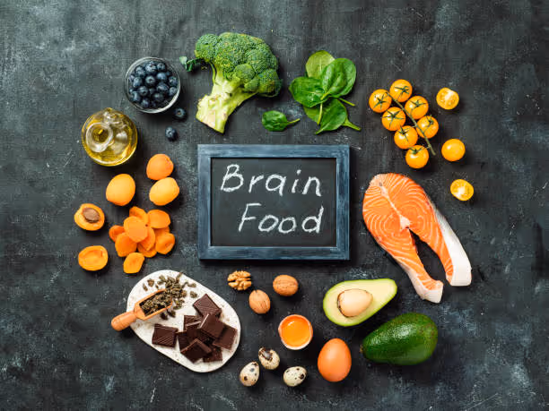Tafel mit der Aufschrift Brain Food, umgeben von gesunden Lebensmitteln für mehr Konzentration