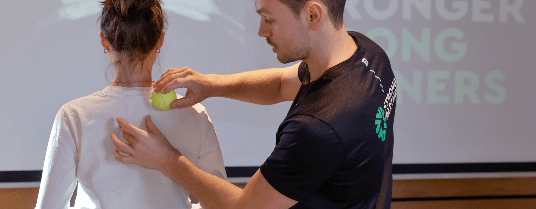 Faszientraining mit dem Tennisball Übung bei zwei Trainern