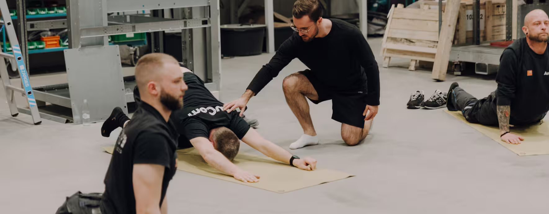 Strong Partners Coach korrigiert eine Übung eines Rückenfit-Kursteilnehmenden