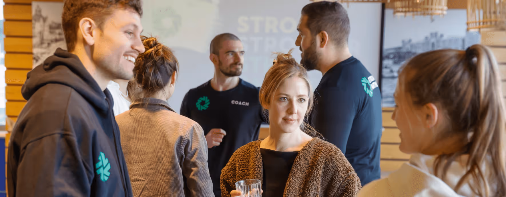Gruppe junger Menschen steht zusammen und unterhält sich vor einem Workshop