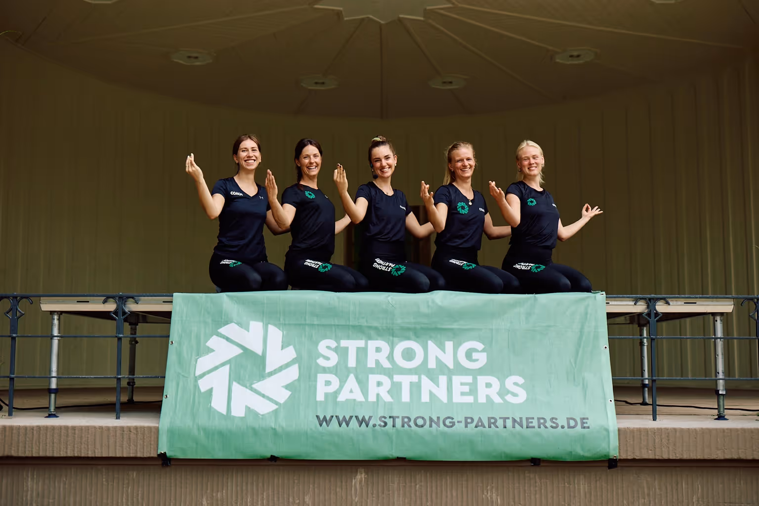 Strong Partners Yoga Coaches auf einer Bühne