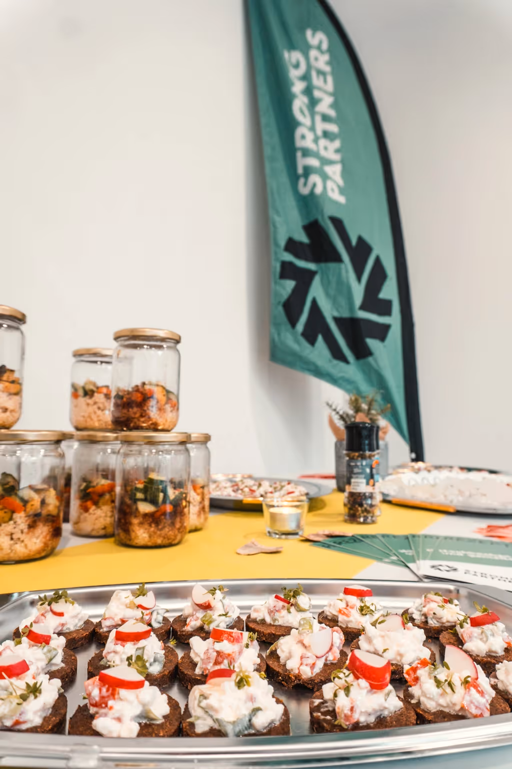 Buffet mit Häppchen, im Hintergrund eine Strong Partners Beachflag