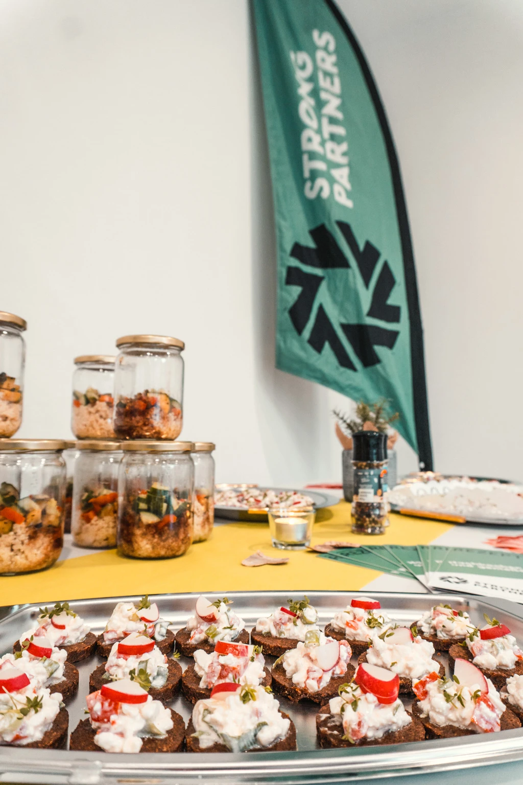 Buffet mit Häppchen, im Hintergrund eine Strong Partners Beachflag
