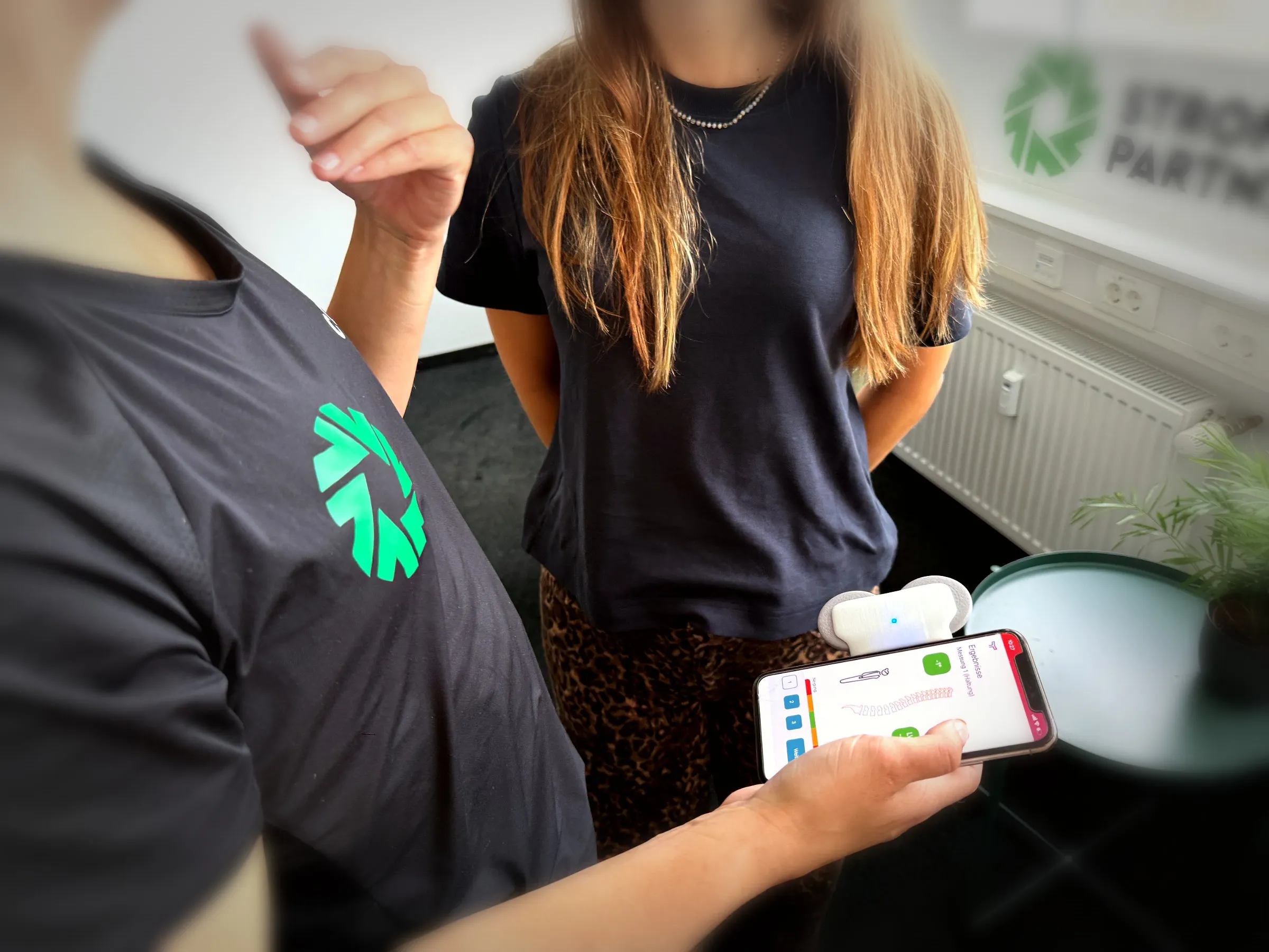 App-Timer der Wirbelsäulenmessung auf dem Smartphone mit aufgesetztem Messsensor.
