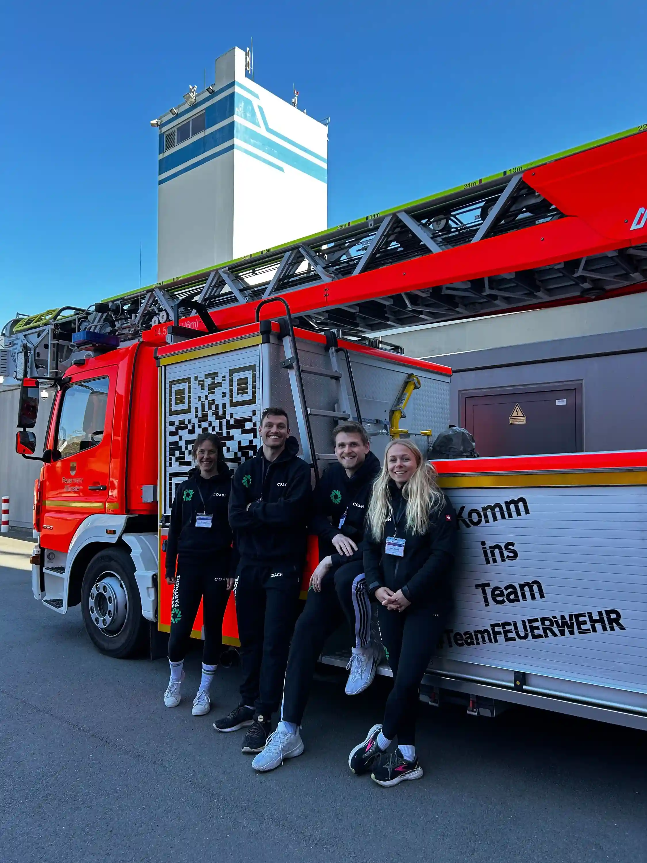 Strong Partners Team vor dem Feuerwehr-Fahrzeug