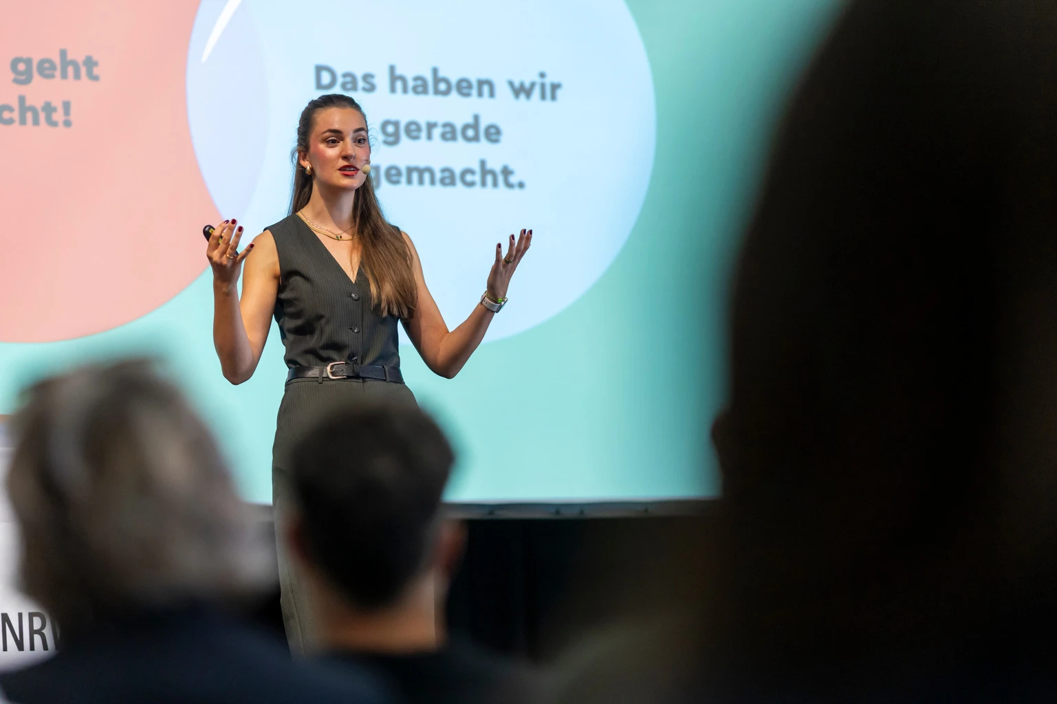 Paula Menninghaus gestikulierend auf der Bühne während eines Vortrags