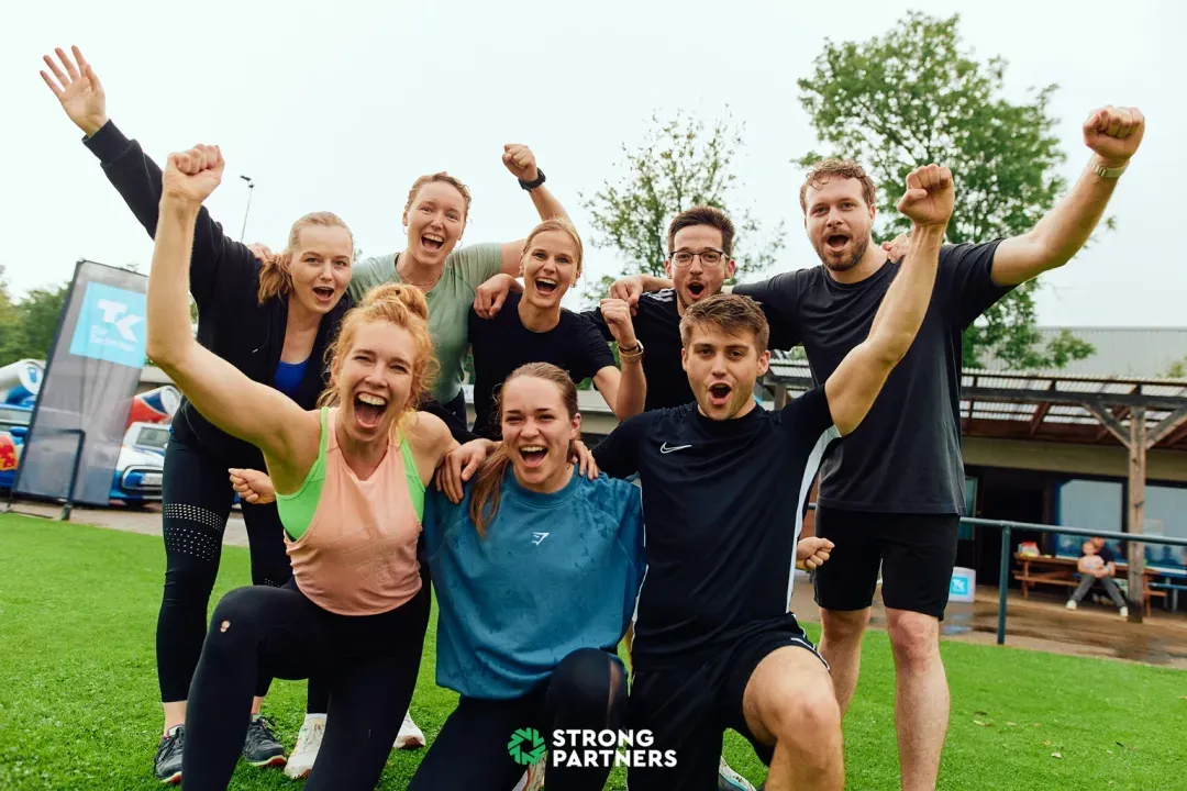 Team von Strong Partners bei einem Gesundheitstag im Unternehmen mit Präsentationsfläche und Markenbranding
