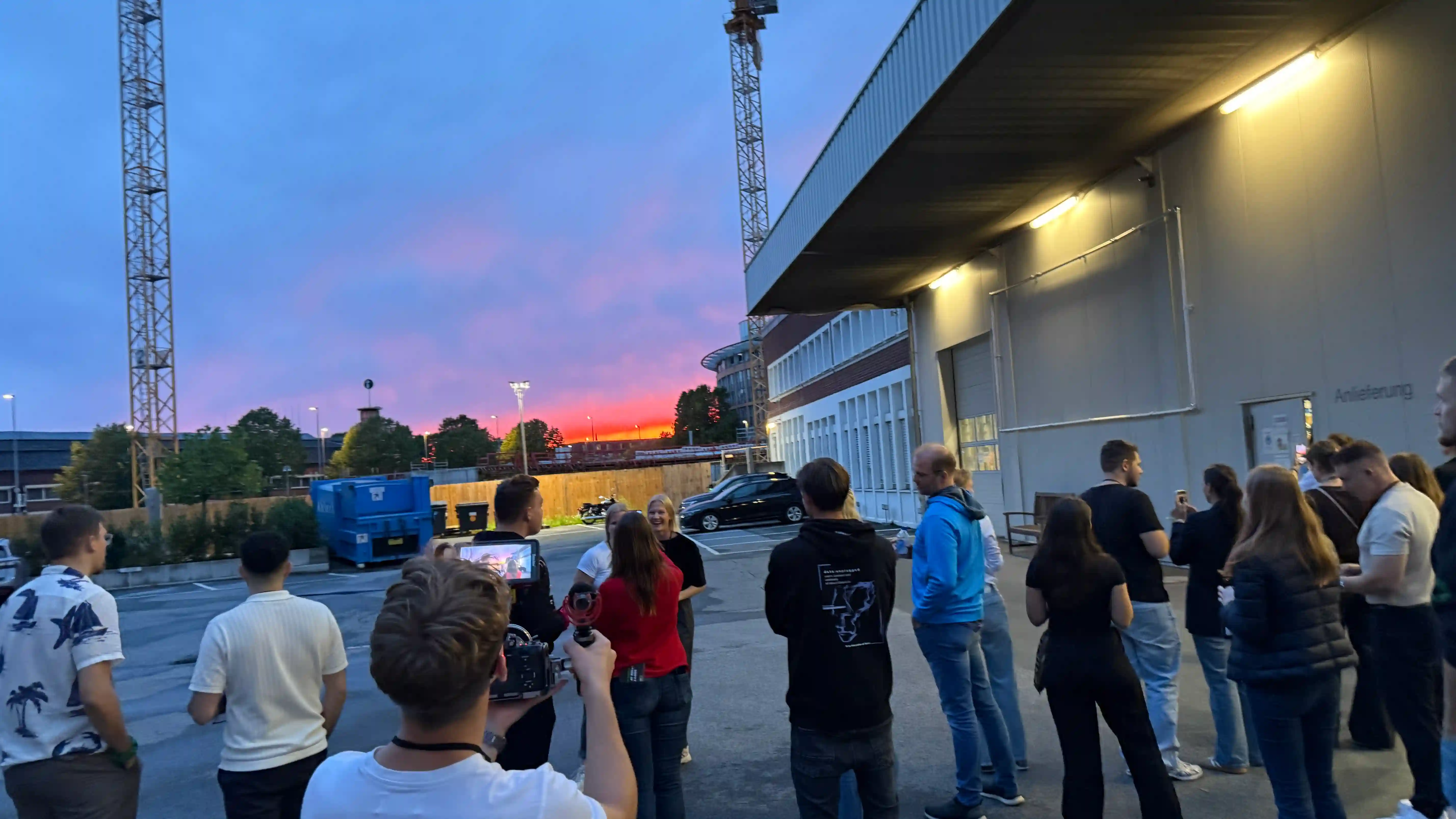 Teilnehmende vom Networkout 2026 stehen auf dem Dermasence-Gelände und beobachten den Sonnenuntergang