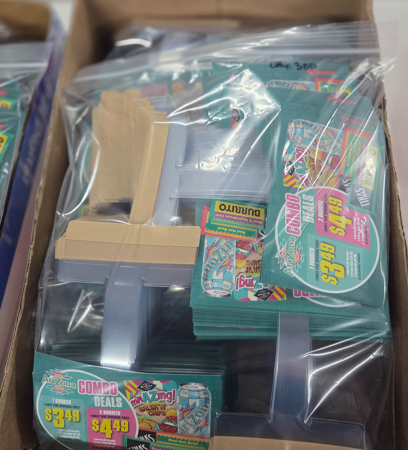 Boxed and bagged AriZona retail price-card graphics staged for shipment