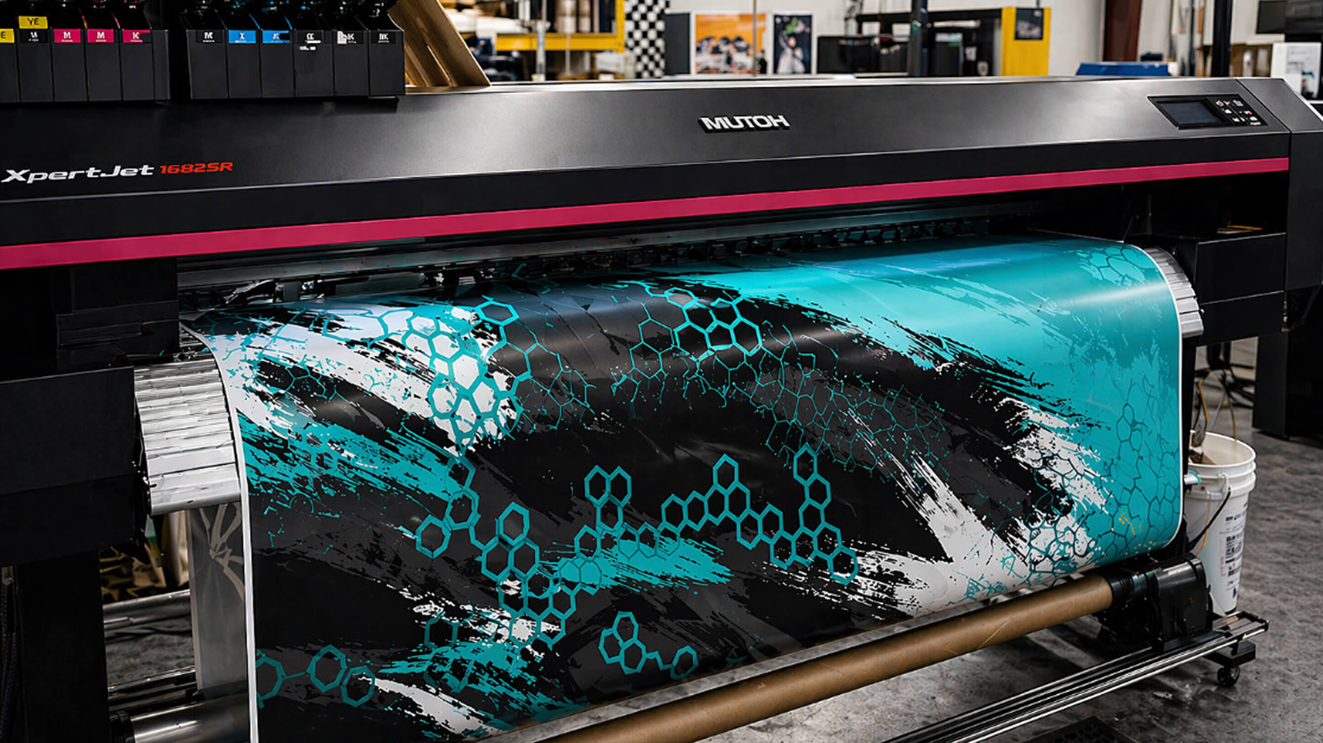 A Mutoh wide-format printer producing a teal-and-black camo vinyl wrap