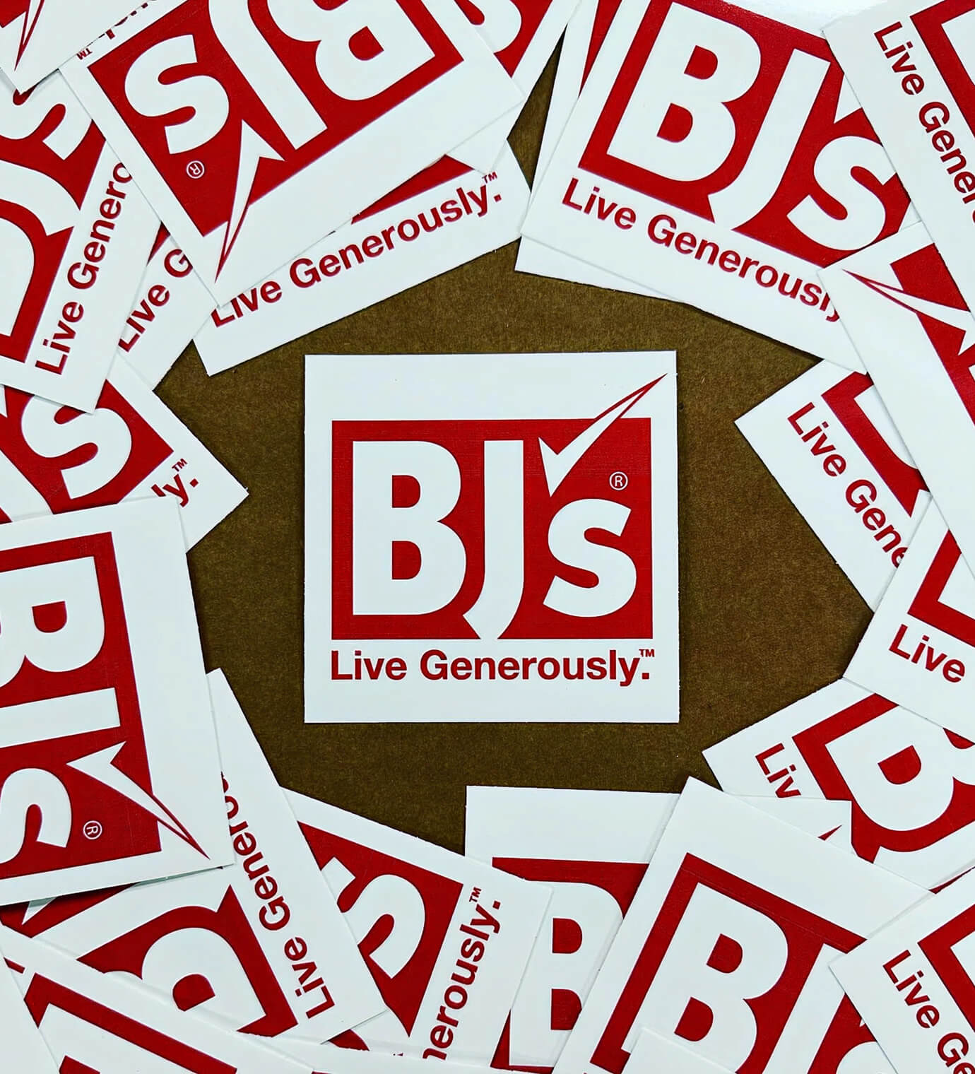 A pile of printed red-and-white BJ's Live Generously branded stickers