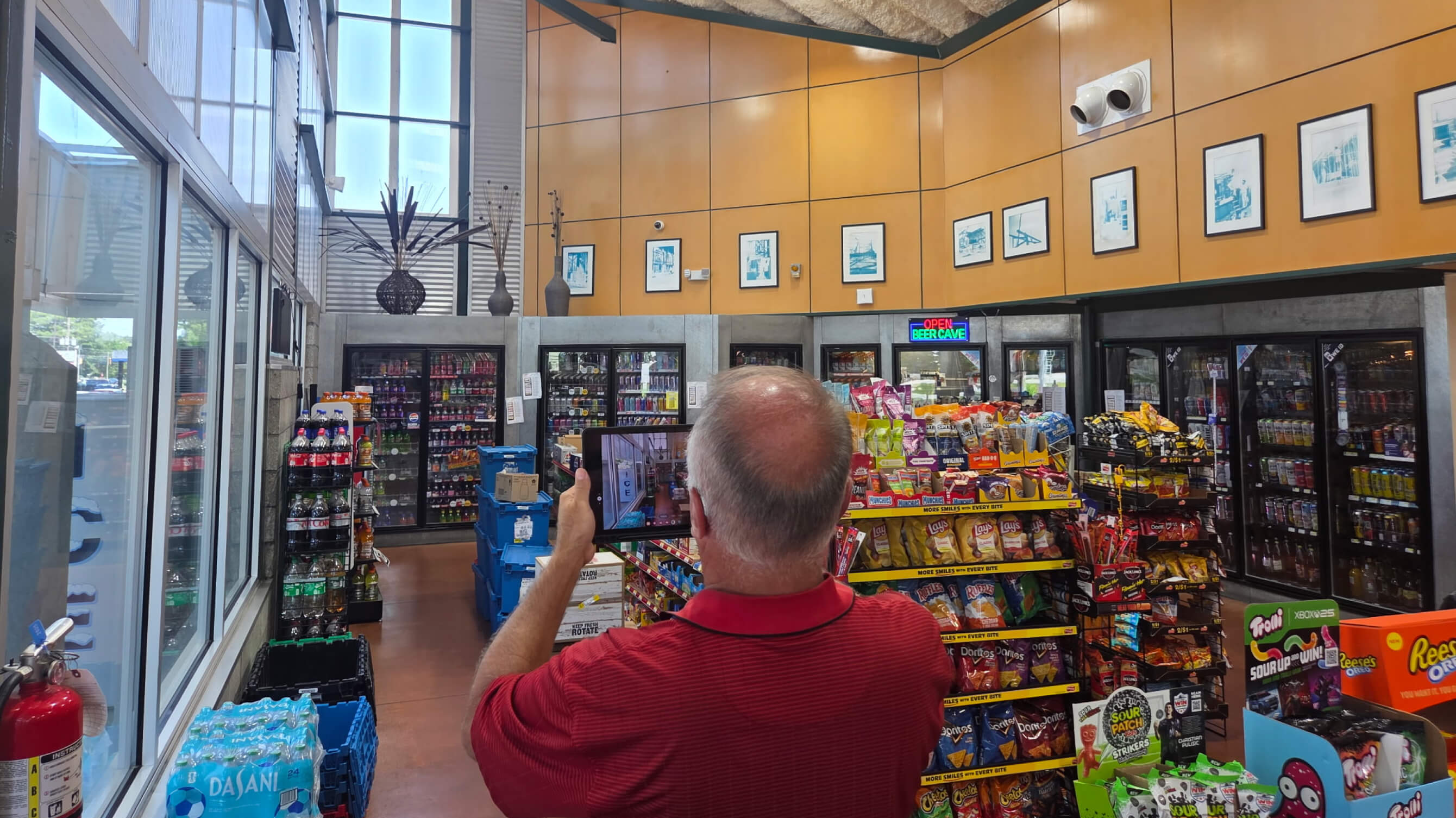 A specialist surveying a convenience-store interior with a tablet
