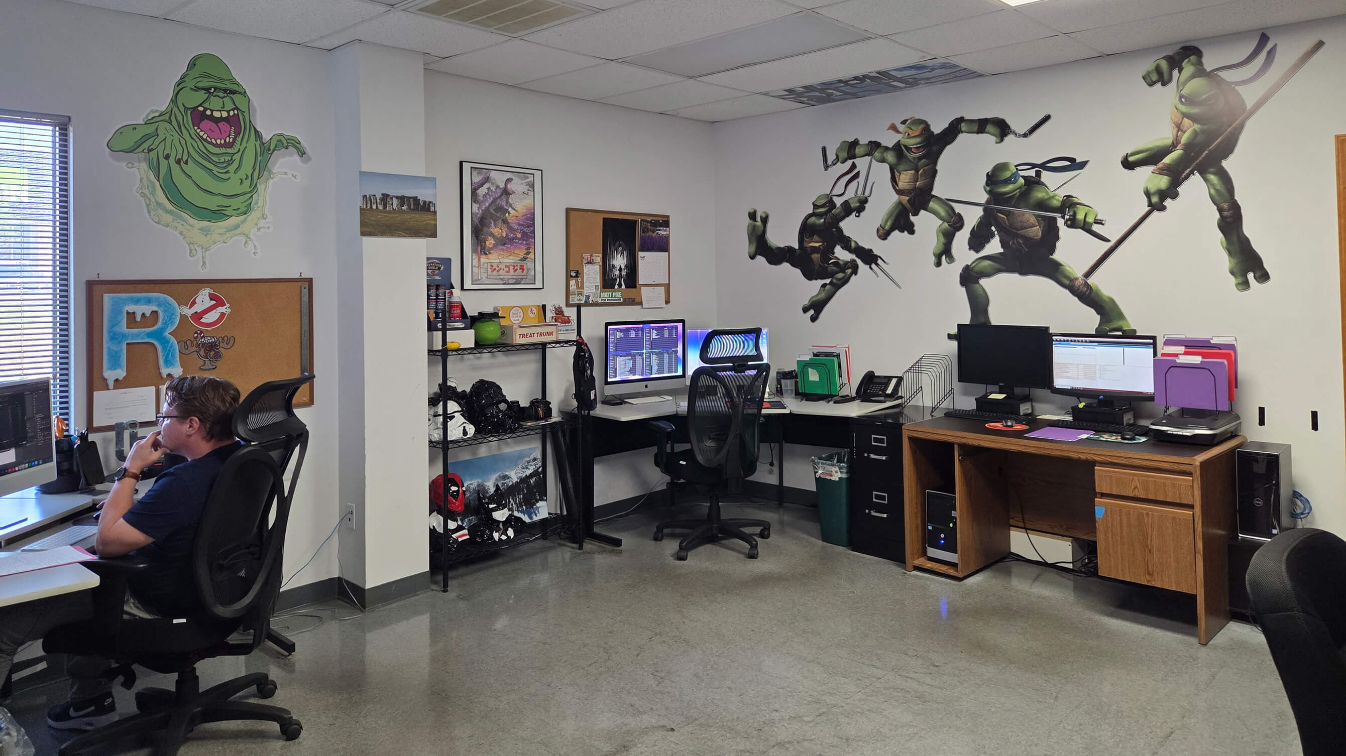 The TEC Graphics design studio with character wall decals and designers at work