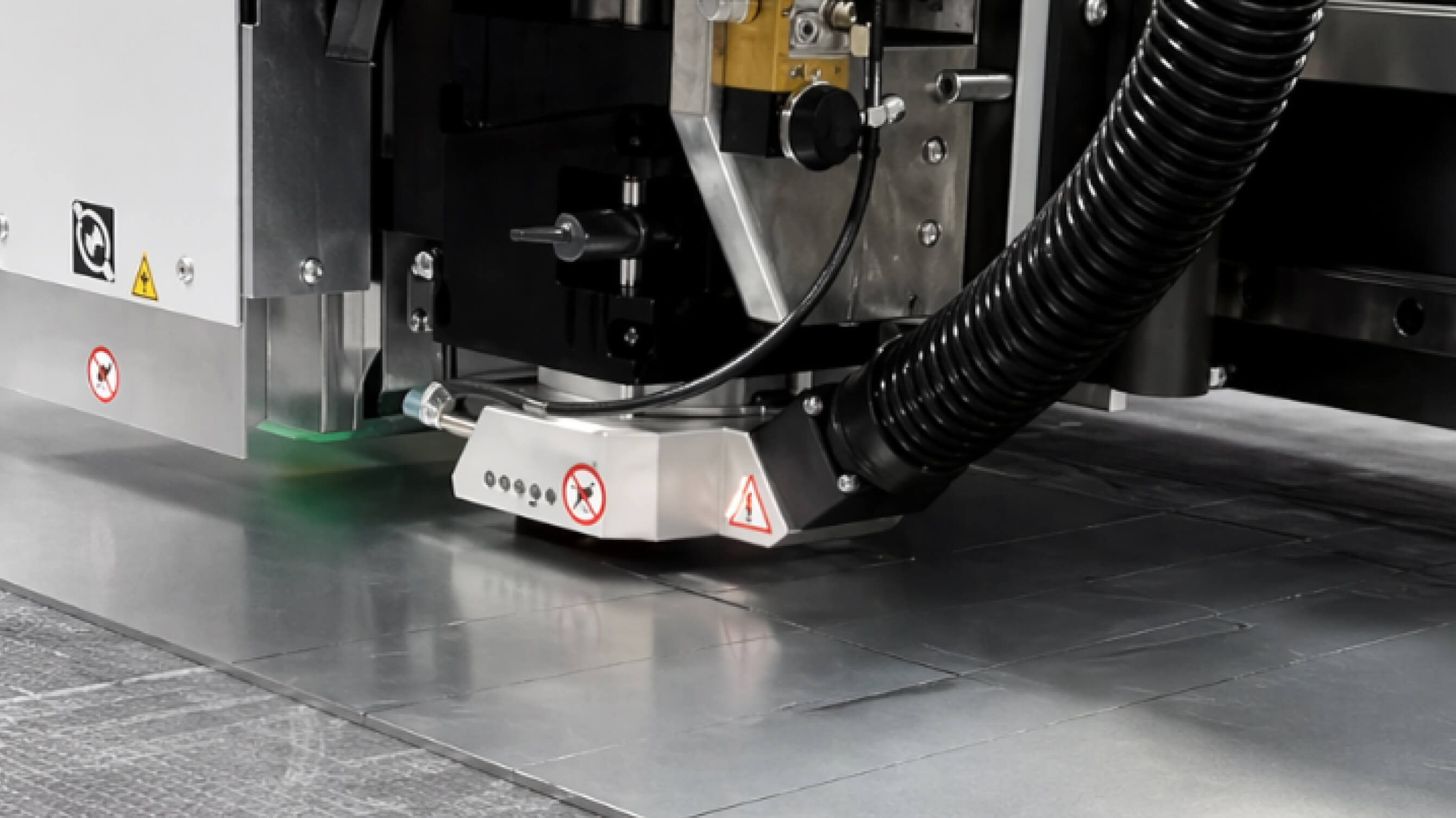 Close-up of a flatbed router's cutting head working across a printed sheet