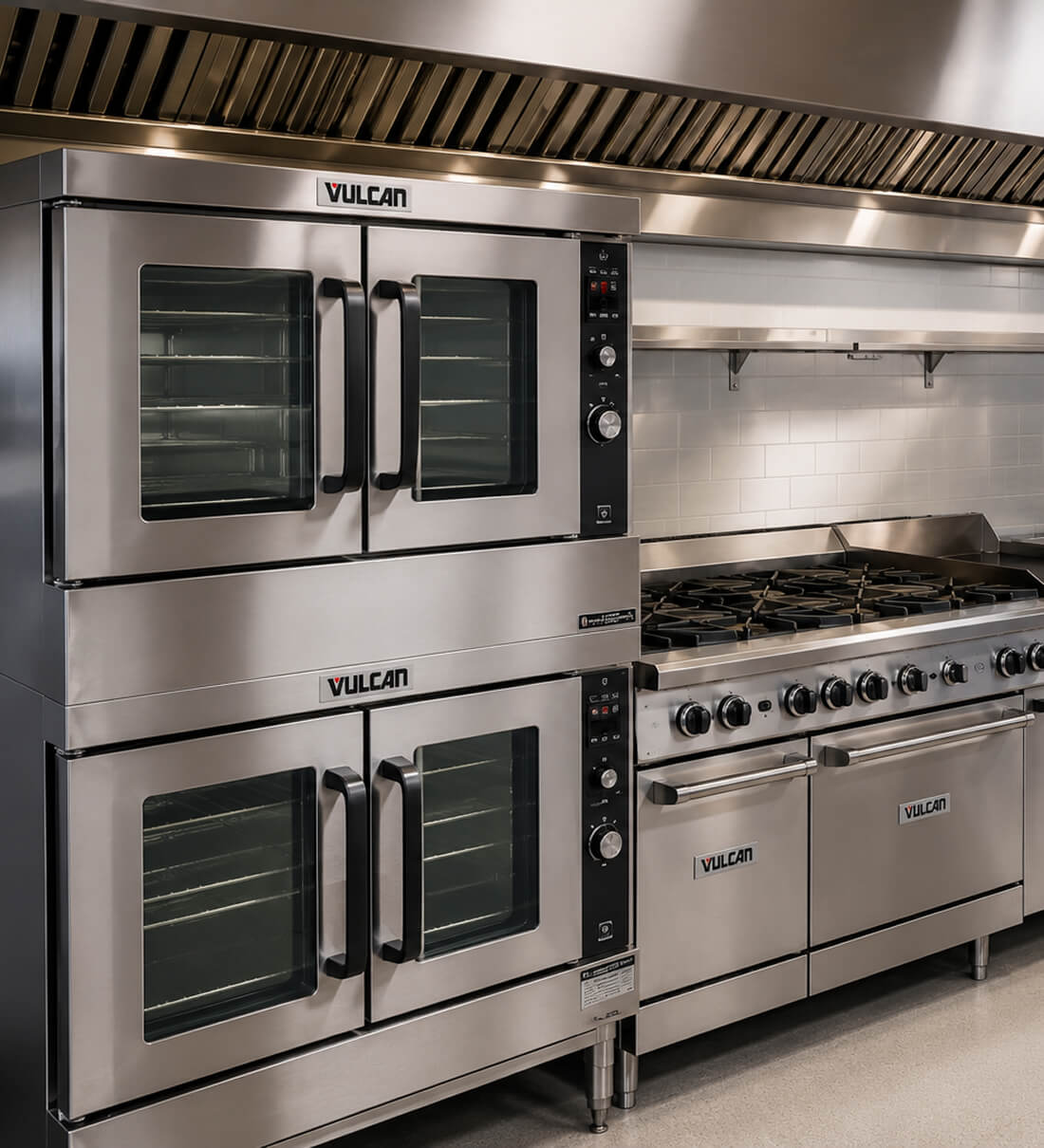 Vulcan commercial convection ovens and gas range with branded nameplates in a stainless kitchen