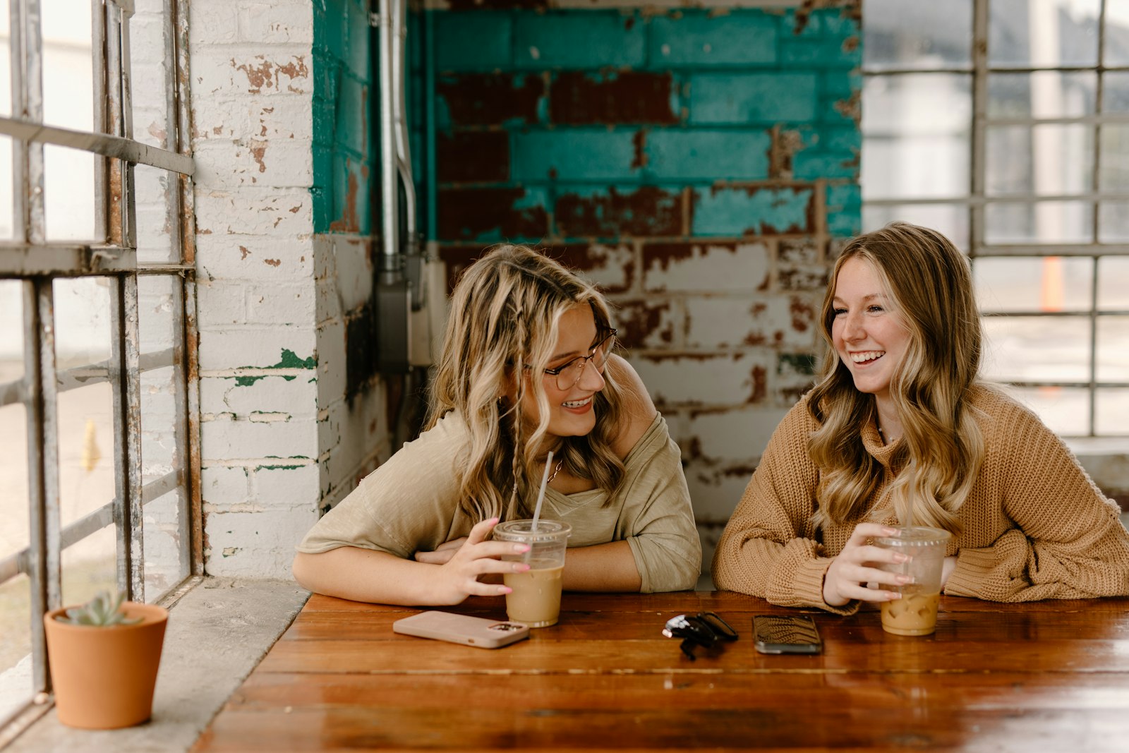 Two friends smiling and talking warmly together over coffee
