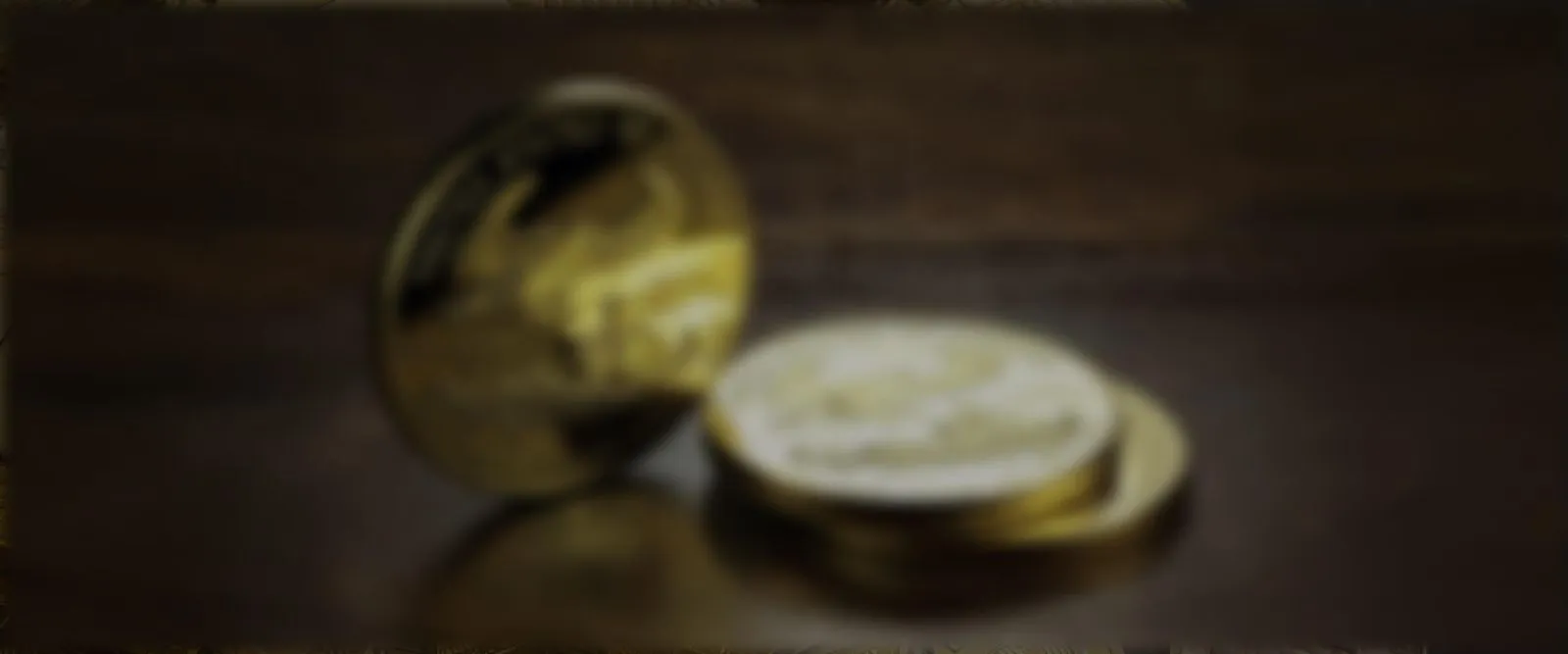 blurry Stack of American Gold Eagle coins on a wooden surface — United States of America 1 oz fine gold $50 coins