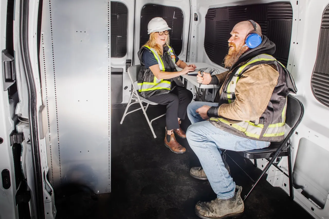 Hearing tester recording a worker's results inside the mobile unit