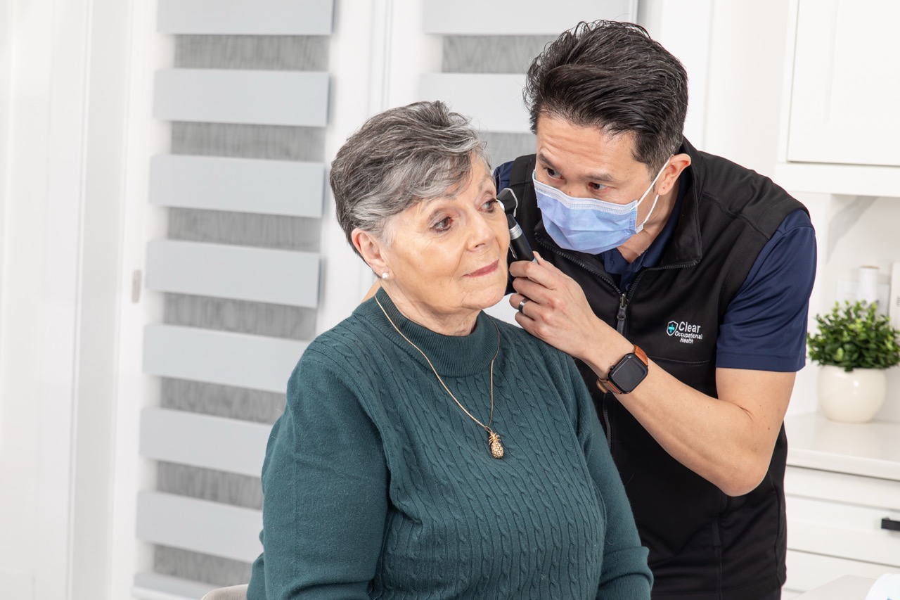Clear Home registered nurse examining a client's ear before in-home ear wax removal