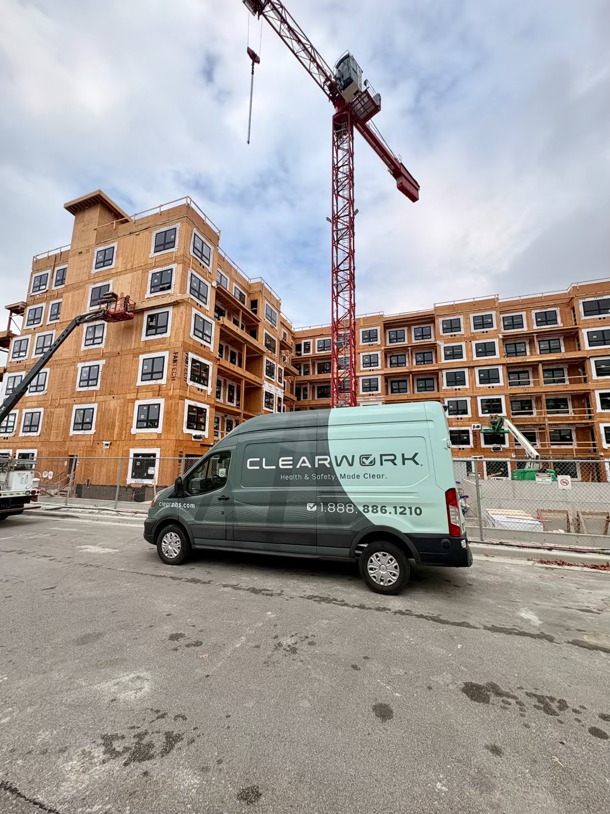 One of the Clear Work mobile testing units on a Langley construction site beneath a tower crane