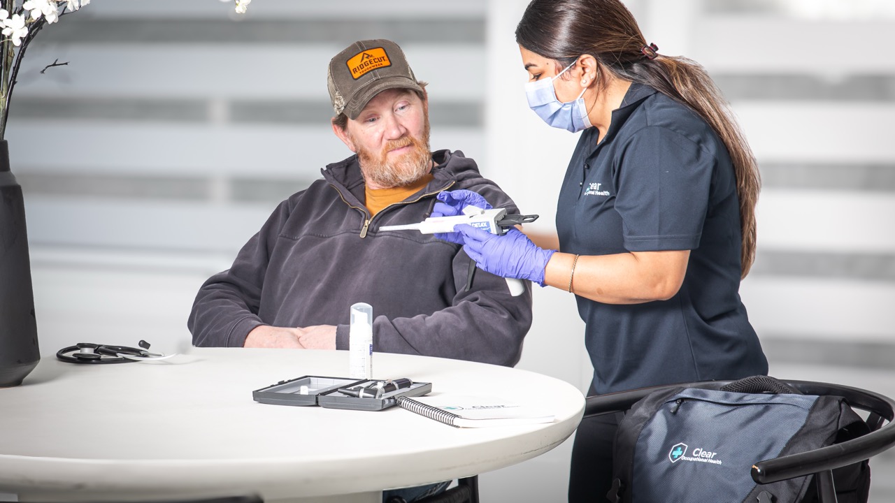 Clear Occupational Health audiologist taking a custom ear mold impression from a worker