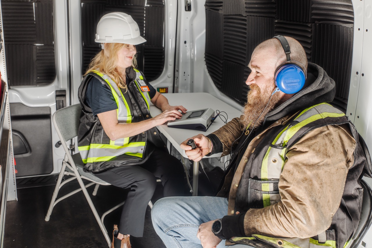 Clear Work hearing tester running an audiometric hearing test for a worker in the mobile testing van