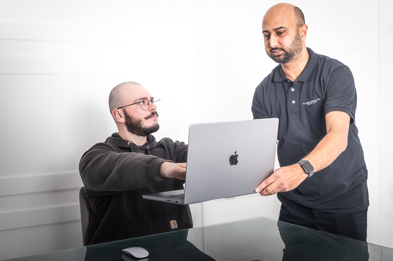 Ergonomic assessor reviewing a worker's screen and desk setup with them