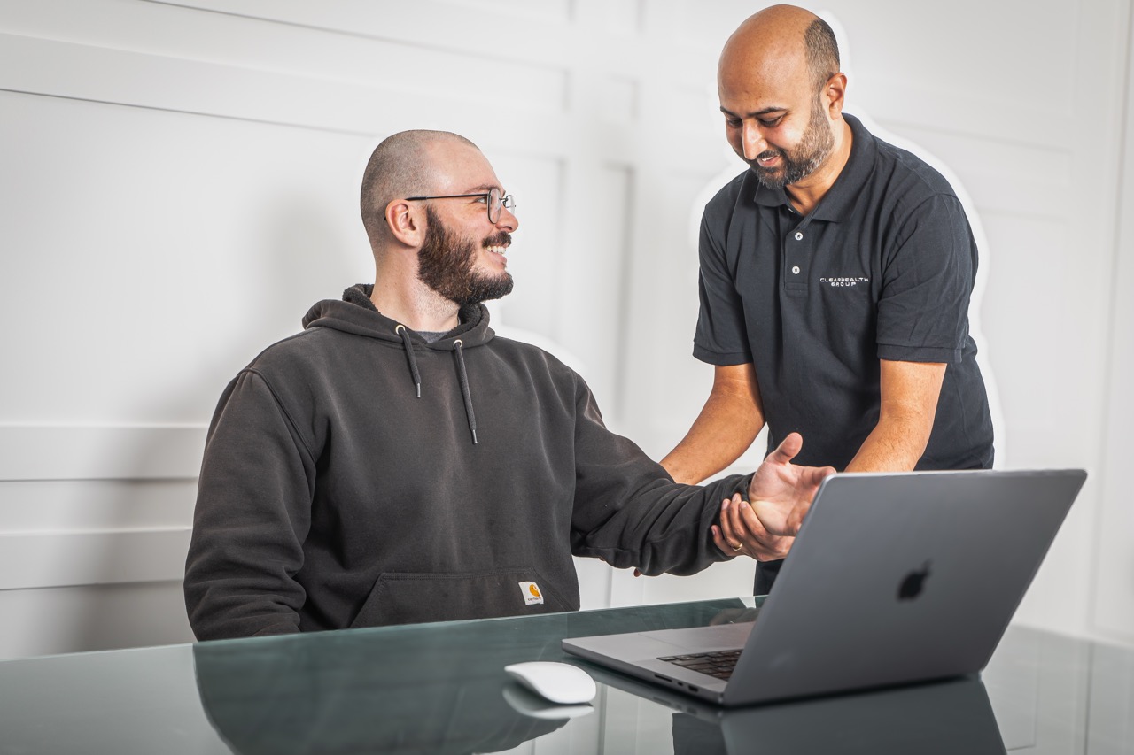Ergonomic assessor examining a worker's hand and wrist at their workstation