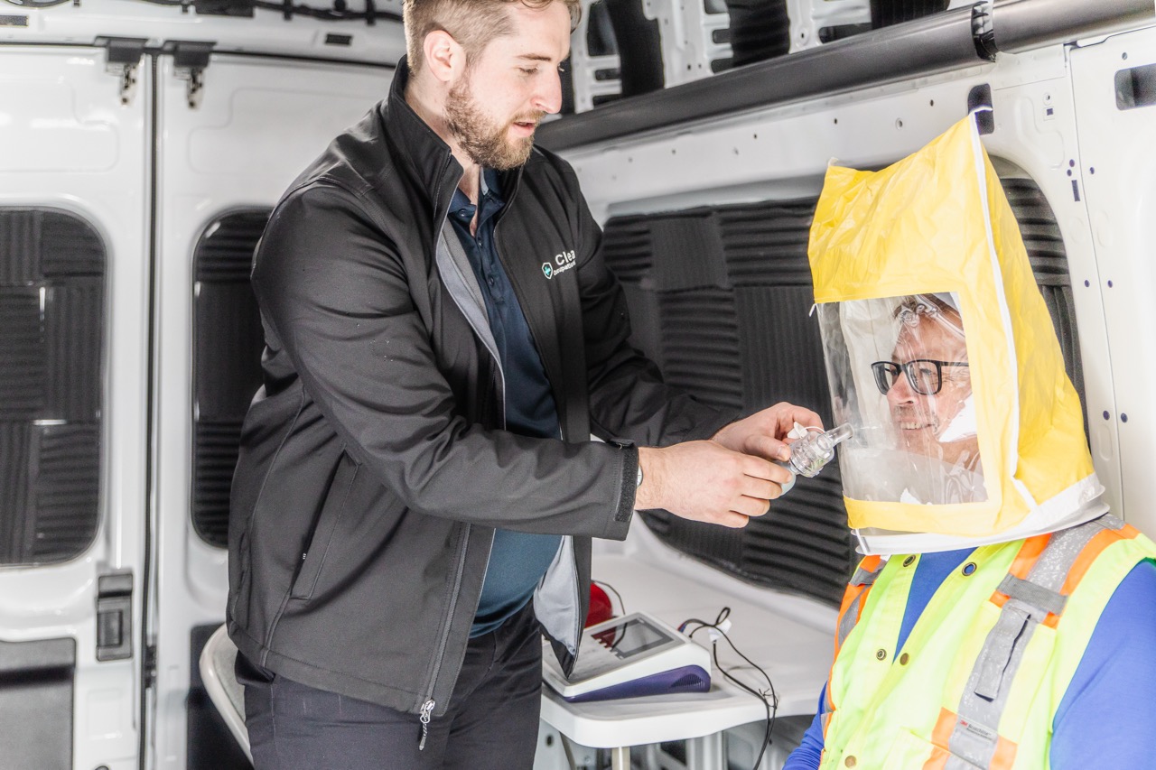 Introducing the test solution into the port of a worker's fit test hood