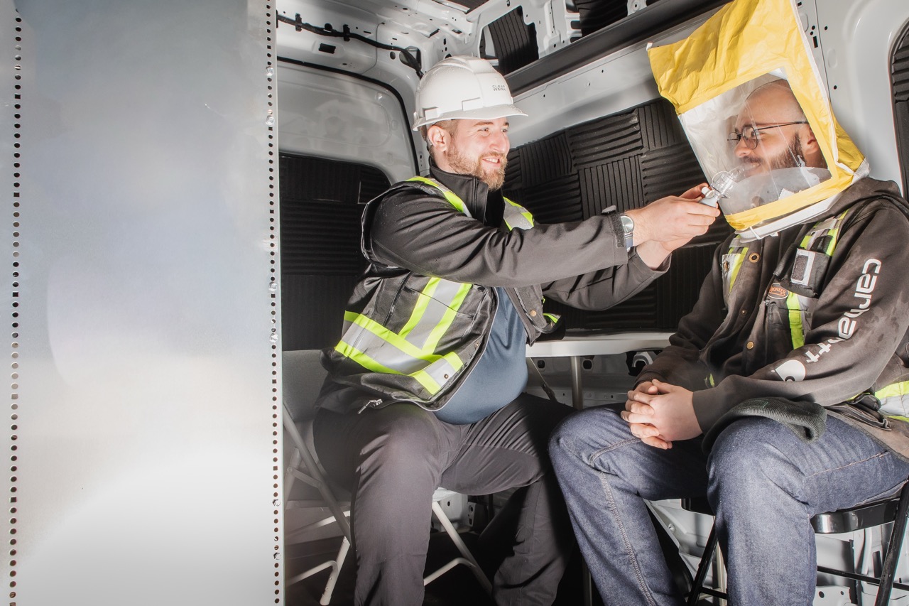 Clear Work technician carrying out a qualitative respirator fit test on a worker in a test hood