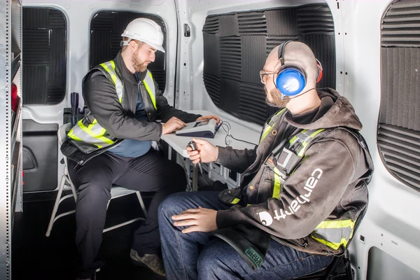 Worker wearing audiometric headphones during an on-site hearing test