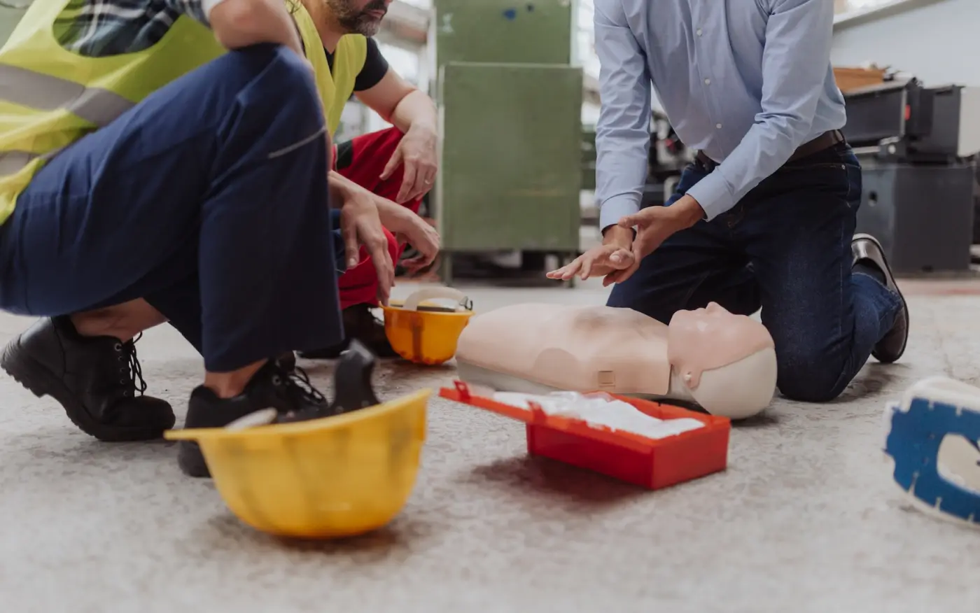 First aid training on a CPR manikin with a crew in hi-vis