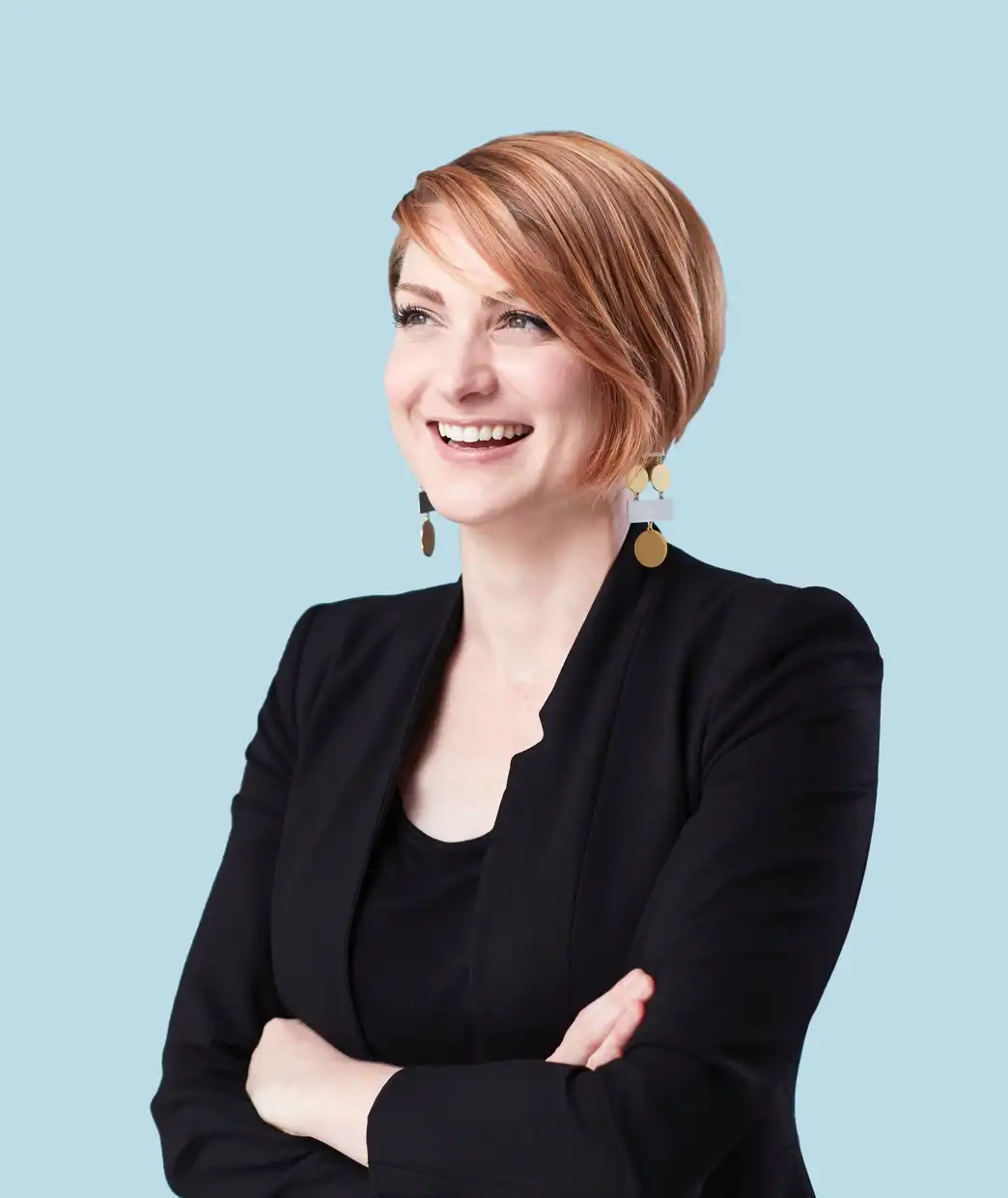 Smiling professional in a black blazer with arms crossed