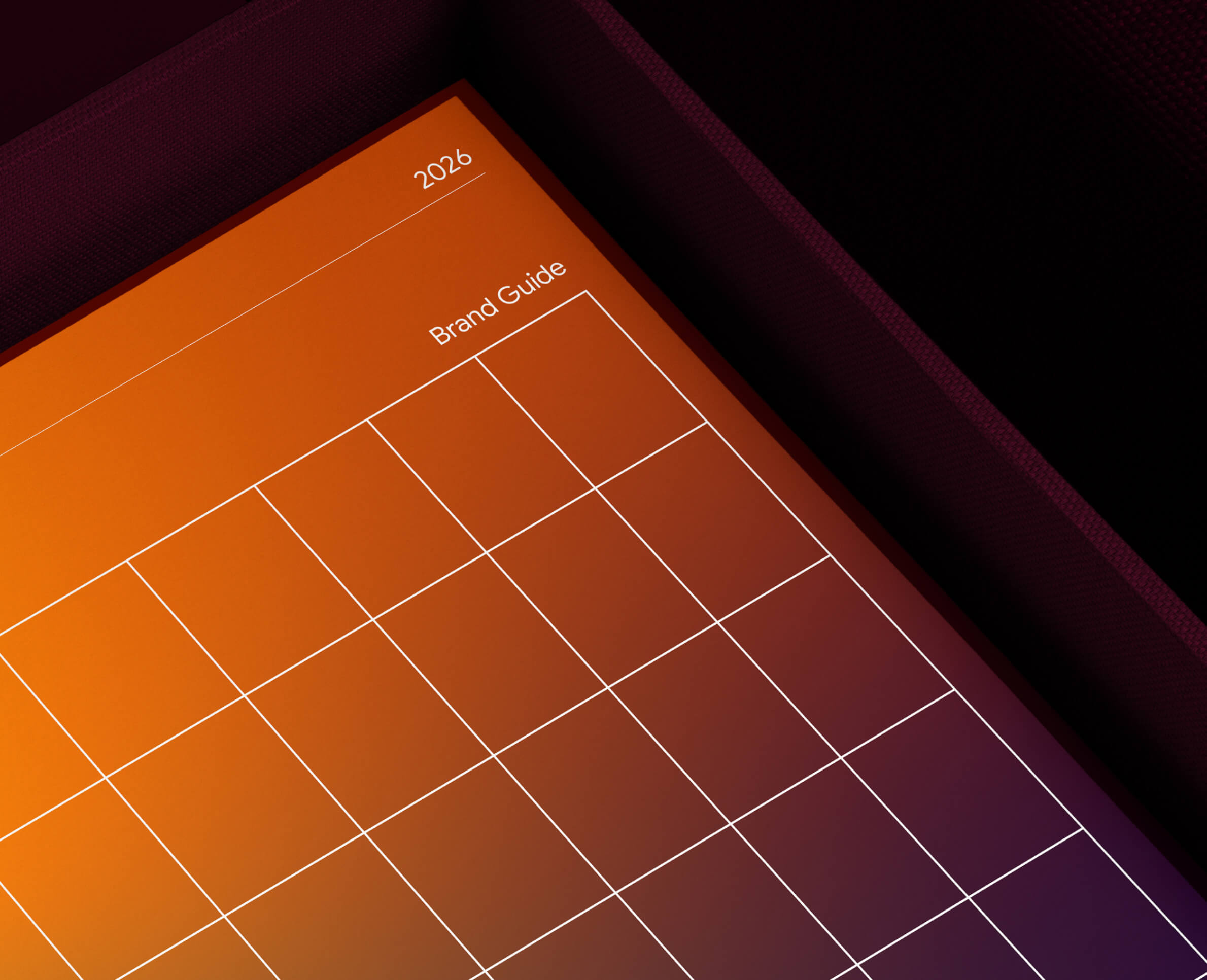 Close-up of a 2026 brand guide calendar with an orange to purple gradient cover inside a dark textured box.