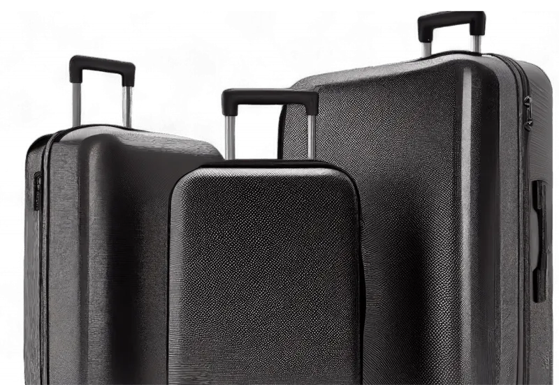 Two black suitcases are standing next to each other.